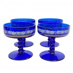Conj. com 4 (quatro) Taças para champagne em vidro na cor azul cobalto, haste torcida, com gravações nas laterais e frisos dourados, med. 10cm de altura. Apresenta desgaste no dourado.