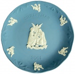 WEDGWOOD - Prato de Natal 2021 em porcelana biscuit na cor azul claro com relevos brancos clássicos, decoração central representa Menino Jesus, José, Maria e Anjo ao fundo, seis decorações menores de anjos com guirlandas florais e sinos de natal ao redor da borda, med. 19cm  