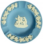 WEDGWOOD - Cinzeiro em porcelana de biscuit na cor azul claro com detalhes em alto relevo com ramos de parreira na borda e figuras mitológicas no centro. Med. 11cm de diâmetro.