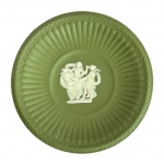 WEDGWOOD - Pequeno prato de Doce em porcelana de biscuit na cor verde sálvia com detalhes em alto relevo branco de figuras mitológicas no centro e borda canelada. Med. 8cm de diâmetro. Na caixa original