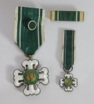MILITARIA - MEDALHA MÉRITO MILITAR EXÉRCITO BRASILEIRO - Fabricada em Bronze e esmalte, com a inscrição `República Federativa do Brasil`. Em ótimo estado de conservação, com fita e alfinete originais. Acompanha o lote a Miniatura da Medalha também com fita original, Roseta e Barreta também originais. A medalha, constituída por uma cruz, no modelo da tradicional Cruz de Aviz, com quatro braços iguais, é concedida por decreto presidencial. Trata-se da mais elevada distinção honorífica do Exército Brasileiro e tem por finalidade premiar militares do Exército que tenham prestado notáveis serviços ao país e cidadãos que tenham prestado relevantes serviços ao Exército.