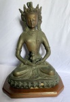 Escultura de bronze  representando divindade oriental, possivelmente a Deusa Guanyin, divindade da misericórdia e da compaixão no budismo, esculturas semelhantes são datadas como sendo do Séc. XIX/XX.  medindo 28 x 21 cm - 6100g Medidas com a  Base de madeira 37cm x 28cm x 21cm - Medidas sem a base 35cm x 23cm x 16cm.