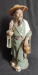 Escultura oriental pescador fortuna em cerâmica e porcelana muito bem confeccionada onde os detalhes chamam a atenção, Na cultura oriental pescador atrai prosperidade, medindo 25 cm de altura por 11 cm de largura