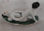 Estatueta de porcelana de casal oriental em cenas eróticas  sobre folha, representando a fertilidade. Med.7,5cm x 4cm