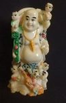 Estatueta Oriental em marfinite do Buda Risonho conhecido como Budai ou Hotai simbolizando abundancia, serenidade e harmonia,  ricamente decorada e policromia, com imperceptivel restauro na cabeça da criança. Alt. 10cm.