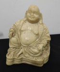 Estatueta em marfinite representando Sidarta Gautama (popularmente conhecido como BUDA)  - Med. 10,5 cm x 8cm x 5cm. - Buda, que em hindu quer dizer Iluminado, foi o nome dado a Siddhartha Gautama, líder religioso que viveu na Índia, cuja bondade e sabedoria lhe valeram esse título. É considerado pelos budistas o Supremo Buda, o fundador do budismo.Buda (Siddartha Gautama) nasceu por volta do ano de 563 a. C. na localidade de Kapilavastu, capital do reino de Sakia, na região setentrional e montanhosa da Índia que hoje faz parte do território do Nepal.