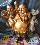 Estatueta de Resina ouro velho representando Buda com Criança no colo, conhecido como Buda Dourado da Fortuna ou Buda da Sorte, associado à prosperidade, riqueza e alegria. Med. 17cm x 24cm x 10cm -