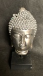 Cabeça prateada de Buda sobre base de madeira com restauro. Alt. 24cm