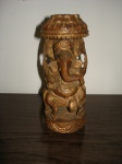 Escultura em madeira representando Deus indiano na med. 15x6 cm.