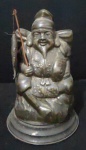 Escultura oriental de bronze com restauro, retratando nobre pescando com vara de pescar e peixe no anzol. Alt. 16cm