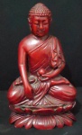 Figura de religioso oriental em meditação segurando uma esfera em resina sólida e pesada na tonalidade sangue de boi. Med. 18cm x 10cm