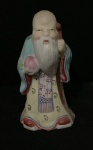 Estatueta de porcelana é provavelmente a representação de um sábio chinês ou do Deus da Sorte (Cai Shen). É uma escultura oriental feita de porcelana policromada.A peça pode ter acabamento fosco e brilhante. Alt. 11cm