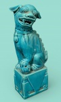 Escultura de cão de fó (Leão guardião chinês)  de Porcelana com esmalte Azul turquesa, Os cães de fó são antigos cães sagrados da Ásia, usados como guardiões, A peça tem uma postura tradicional, com uma das patas apoiada sobre uma esfera vazada. .  com 17cm de altura.
