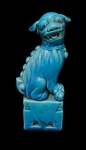Escultura de cão de fó (Leão guardião chinês)  de Porcelana com esmalte Azul turquesa, Os cães de fó são antigos cães sagrados da Ásia, usados como guardiões, A peça tem uma postura tradicional, com uma das patas apoiada sobre uma esfera vazada. .  com 16cm de altura.
