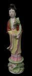 Escultura Oriental de Porcelana, possivelmente representando Kuan Yin, Símbolo supremo de compaixão e misericórdia, é reverenciada há séculos como a divindade que ouve os lamentos do mundo, trazendo paz, proteção e esperança. Apresenta restauro no pescoço, com 30,5cm de altura.