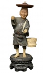 Escultura de Bronze cor marfim sobre base de madeira representando representando camponês com chapéu  podendo se tratar de escultura do período Meiji com 18 cm de altura