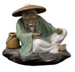 Estatueta chinesa elaborada com terracota vitrificada de figura supostamente pescador com rica policromia, marcada e numerada na base, numero 62, medindo 15cm x 17cm x 12,5cm