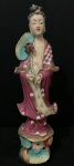 Escultura de porcelana oriental. Representa uma figura feminina, possivelmente uma dama ou gueixa, com trajes típicos. A peça possui rica policromia e detalhes de pintura floral.  com 25 cm de altura