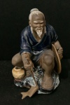 Escultura oriental de pescador chines  feita de porcelana com 14 cm de altura.