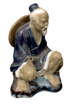 Antiga escultura de pescador em porcelana chinesa. Representa um pescador sentado, com perda do braço direito e com 12cm de altura.