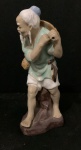 Antiga escultura chinesa de porcelana representando um pescador. A peça é frequentemente descrita como feita à mão e policromada (pintada com várias cores). É considerada um item de colecionador e pode datar de décadas passadas, como os anos 60 ou 70. com 17 cm de altura.
