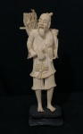 Estatueta antiga cor marfim esculpido à mão, representando um ancião ou lenhador chinês, apoiada sobre uma base de madeira de origem chinês ou japonês, frequentemente datada dos séculos XIX ou XX.  Detalhes: Representa figuras tradicionais como lenhadores, pescadores ou sábios com 15cm com base de madeira - Sem base 13cm