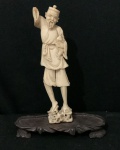 Escultura chinesa esculpida em cor marfim antigo (sex. XIX)  com figura de ancião segurando um peixe retratando  pescador. - Ausência do chapéu e mão direita - altura com base de madeira 17cm - Sem a base 15,5cm