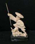 Escultura cor marfim oriental representando pescador sobre base de madeira . Altura com a base 10cm - Sem a base 8cm