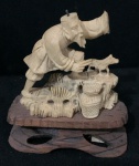 Escultura de Pescador cor marfim oriental com base de madeira  - Ausência do chapéu e da mão esquerda - altura com a base 9,5cm - Sem a base 7cm