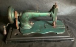 Maquina de costura muito antiga de manivela e engrenagem na cor verde com base de caixa de madeira. No estado, Med. 24cm x 22cm x 44cm
