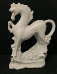 Escultura representando cavalo de porcelana branca. Med 17cm x 13cm x 5cm