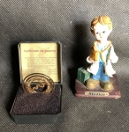 Lote com estatueta de médico em resina com base em madeira com 11cm de altura e pingente da MarkBen com banho de ouro 18k com 40mm de diâmetro e acondicionado na caixa original com certificado.