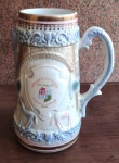 Invulgar e gigante caneca para chopp de coleção de cerâmica com desenhos de casal em alto relevo com bordado decorada a ouro e com rica policromia. Diâmetro da base 16cm - Altura 30 cm - Peso 2230g. Base rosa filetada a ouro. Manufaturada no ano de 1974 para o 6. festival do chopp da Associação Satélite Prontidão. Porto Alegre - RS.