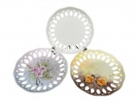 PORCELANAS, lote com três (3) pratos decorativos confeccionados em porcelana na tonalidade branca com borda em vazados e 2 com pintura floral em policromia, medindo 19,5cm.