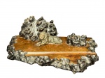 DIVERSOS, um (1) tinteiro confeccionado em madeira escura com entalhes representando formações rochosas, encimado por escultura em bronze representando leão, 2 cavidades com ausência do recipiente em vidro, medindo 12x37x22cm, apresenta lascado na madeira.