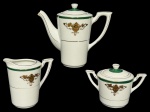 PORCELANA MOGY DAS CRUZES, lote com três (3) peças confeccionadas em porcelana na tonalidade branca, decorada por espessas faixas na tonalidade verde com pintura floral e filetes em ouro, sendo: A) 1 bule para café, medindo 16x19x9cm (quebra no bico), B) 1 leiteira, medindo 10,5x11x7cm e C) 1 açucareiro, medindo 9x13x8cm.