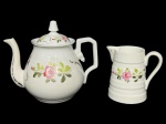 PORCELANA VISTA ALEGRE (Manufatura portuguesa fundada em 1824, referência mundial em porcelana fina), lote com duas (2) peças confeccionadas em porcelana portuguesa na tonalidade branca, ambas com pintura floral em policromia com filetes em ouro, sendo: A) 1 bule para chá, medindo 18x20x9cm e B) 1 leiteira, medindo 11,5x12x7cm.
