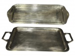 METAL PRATEADO, duas (2) bandejas retangulares confeccionadas em metal espessurado a prata, sendo: A) 1 da manufatura WOLFF, cinzelada por caneluras e fitas cruzadas, apresentam falhas na prateação, medindo 33x14cm, B) 1 da manufatura BRISTOL, fundo liso e alças vazadas, medindo 27x16cm.