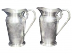 METAL PRATEADO, duas (2) jarras refresqueiras confeccionadas em metal espessurado a prata da manufatura EBERLE com cinzelado de elementos vegetalistas, 1 apresenta mossa na base, medindo 22x20x13cm.