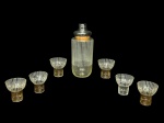 VIDROS, conjunto para coquetel com sete (7) peças confeccionadas em vidro translucido ao gosto anos 50 com decoração de faixas brancas e em ouro, sendo: A) 1 coqueteleira com tampa em metal com sinais de oxidação, medindo 22cm e C) 6 copos para coquetel, medindo 7x7cm 1 com rachadura, trincado na borda e com falhas na douração.