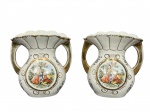 PORCELANA SÃO PEDRO, par (2) de vasos ânforas confeccionados em porcelana na tonalidade branca, decorado por elementos vegetalistas, florais e caneluras em ouro, centro em reserva representando cena galante em policromia, apresenta falhas na douração, medindo 19x17x10,5cm.