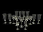 VIDROS, quinze (15) taças confeccionadas em vidro translucido com lapidação de frisos horizontais e esferas com pendantes em baixo relevo, haste cilindrica apoiada sobre base circular, sendo: A) 8 flutes, medindo 17,5x6,5cm, B) 5 para vinho, medindo 15x7cm, C) 1 para vinho do porto, medindo 10x4cm e D) 1 para licor, medindo 11x3,5cm.