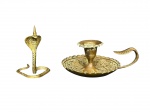 BRONZES, lote com duas (2) peças confeccionadas em bronze, sendo: A) 1 castiçal palmatória com rico cinzelado vegetalista com inscrições em arábe, medindo 6x13cm e B) 1 castiçal representando cobra, medindo 8,5cm.
