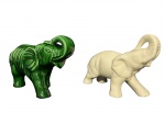 ESCULTURAS, duas (2) esculturas confeccionadas em faiança vitrificada representando elefantes, sendo 1 na tonalidade verde e 1 na tonalidade branca, medindo 22x35cm, branco possui bicado na lateral.