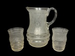 VIDROS, três (3) peças, sendo: A) 1 jarra, medindo 21x17x11,5cm e B) 2 copos para água, medindo 11x7,5cm (1 bicado), confeccionados em vidro com decoração floral jateada na tonalidade branca.