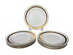 PORCELANA REAL, nove (9) pratos rasos confeccionados em porcelana nacional na tonalidade branca decorado por espessa faixa em ouro decorado por guirlanda floral com arremates e filetes em douração, medindo 25cm. 2 bicados.