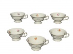 KPM Krister Porzellan-Manufaktur (Fundada em 1831 por Carl Franz Krister), seis (6) xícaras para café sem pires confeccionadas em porcelana na tonalidade branca, elementos vegetalistas em relevo na pasta, pintura de flores e folhagens em policromia e borda filetada em ouro, medindo 4x9x8cm.