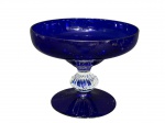 CRISTAL, uma (1) fruteira de pé confeccionada em cristal na tonalidade azul cobalto, haste translucida moldada em gomos, apoiada sobre base circular, medindo 18,5x23,5cm.