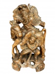 ESCULTURA ORIENTAL, uma (1) escultura confeccionada em madeira entalhada a mão representando figura guerreira em cena dinâmica, acompanhada de cavalo e personagem secundário, ricamente trabalhada em alto-relevo e vazados, medindo 33x18cm.