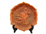 DIVERSOS, um (1) prato decorativo confeccionado em laca na tonalidade vermelho cinábrio, ricamente trabalhado em alto-relevo, representando figura oriental montada sobre dragão, em composição simbólica associada à mitologia e tradição asiática, com elementos de nuvens e movimento, medindo 22x24,5cm.